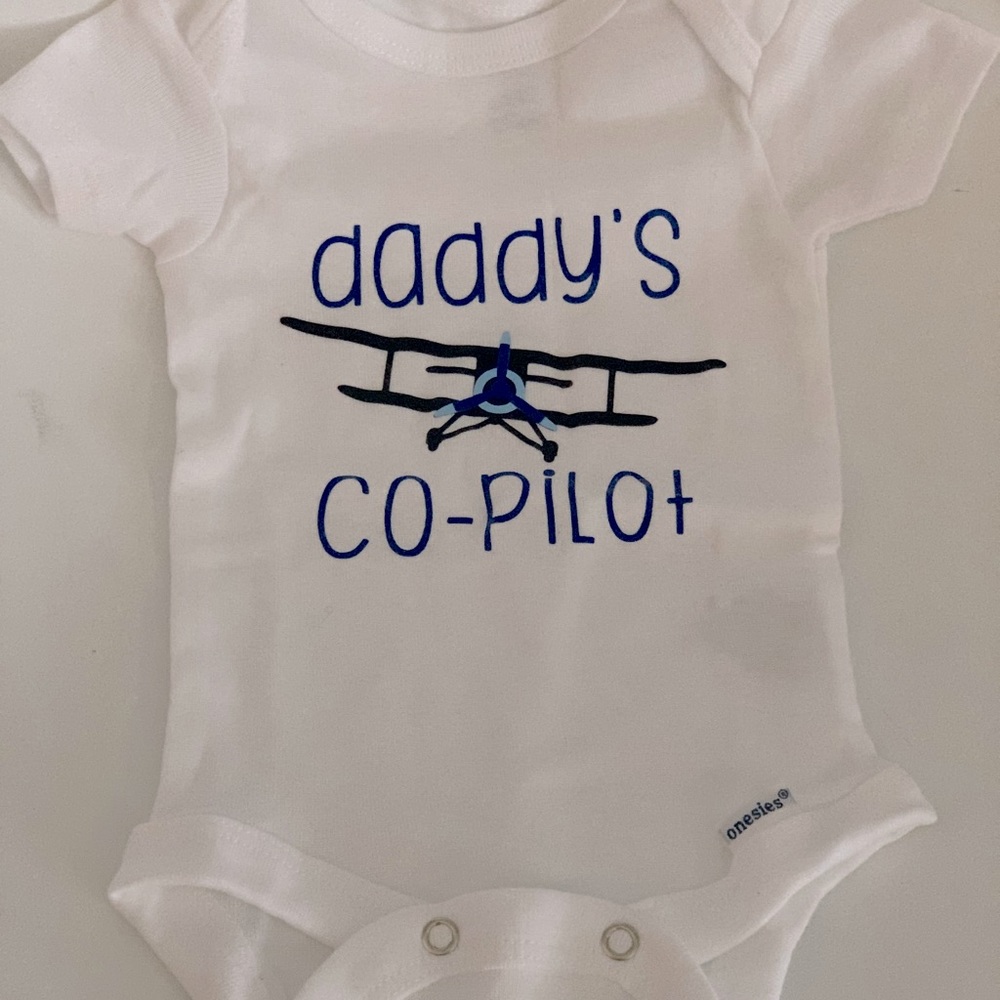 Never worn Daddy’s Co-Pilot newborn onesie